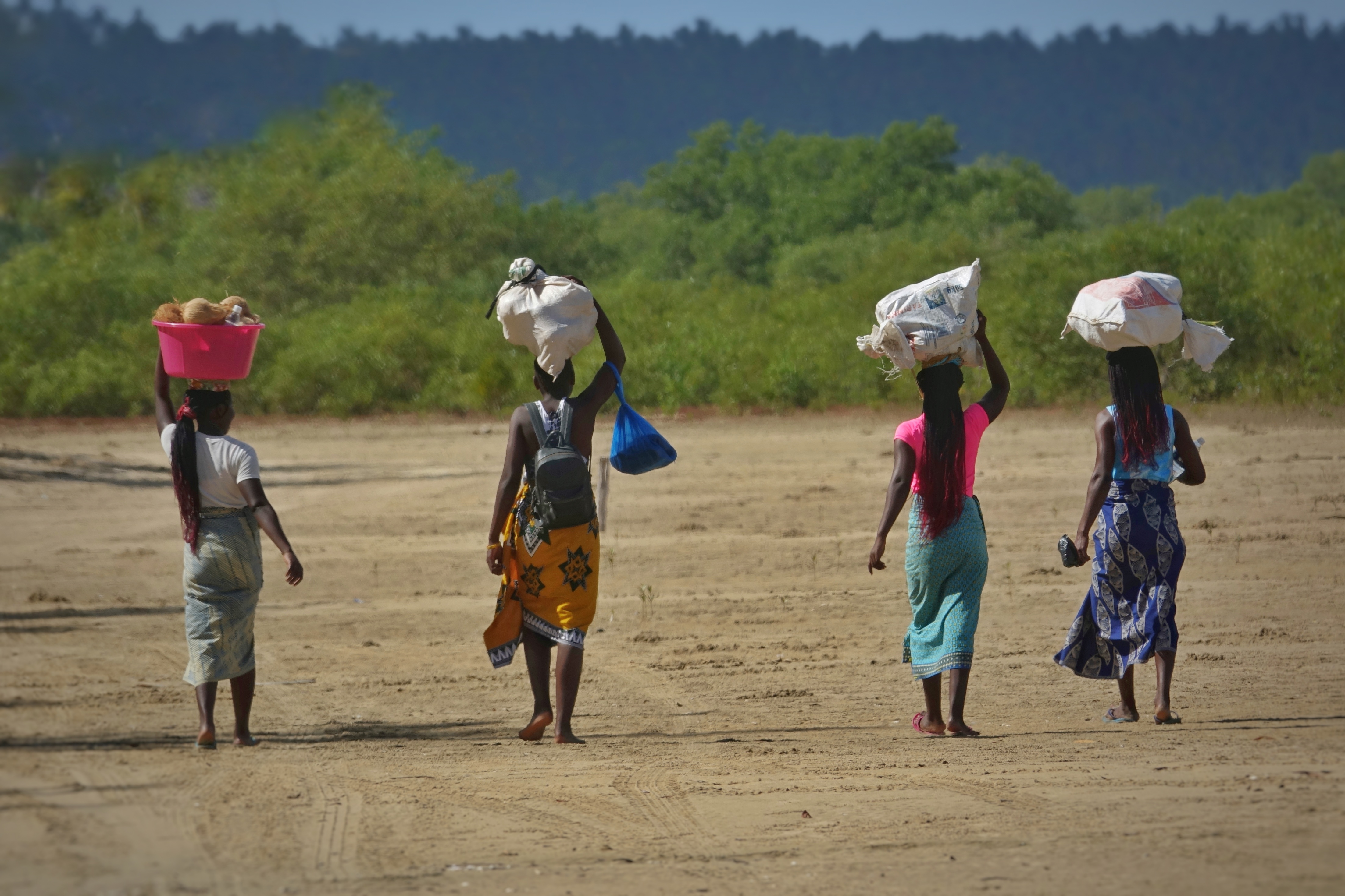Femmes portant des charges sur la plage